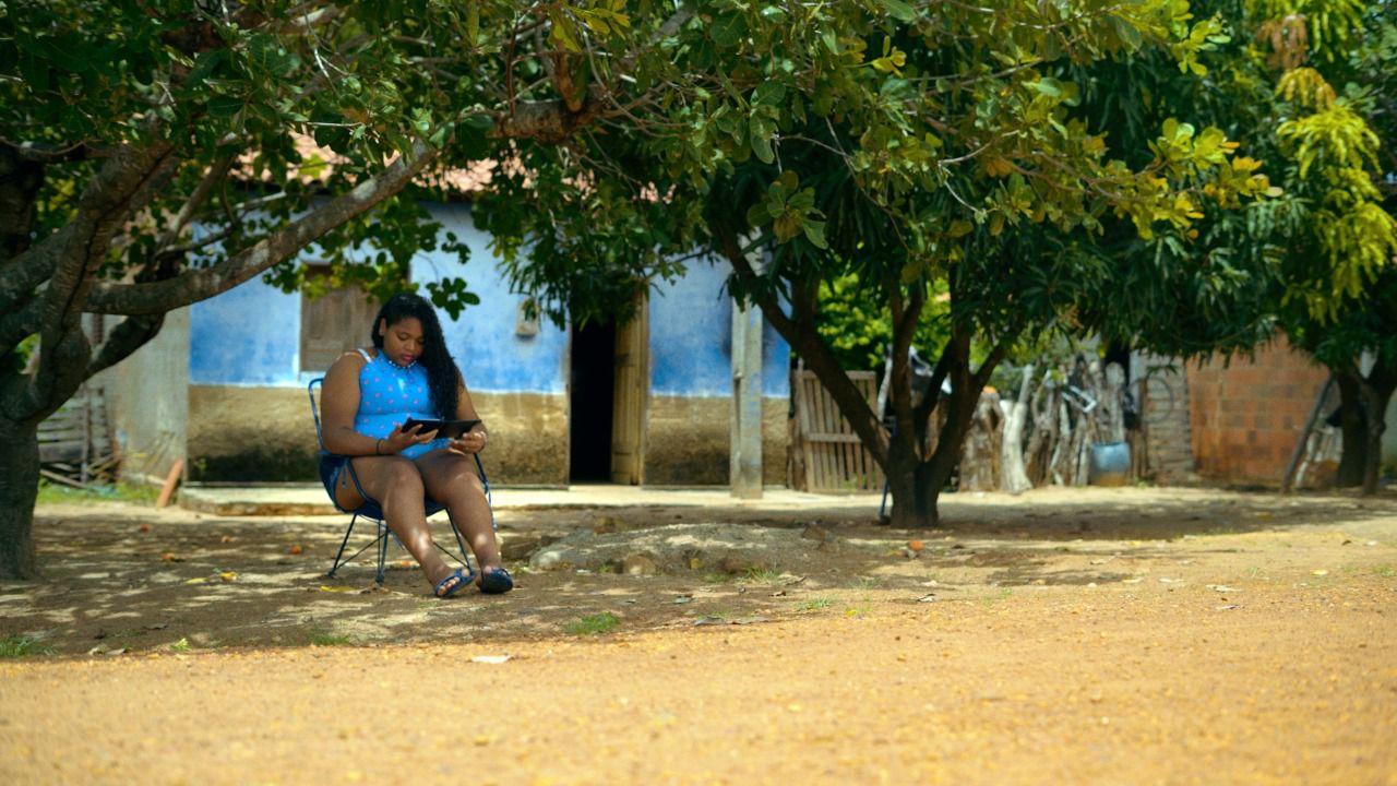 Estudante usando um tablet à sombra de uma árvore no interior do Piauí
