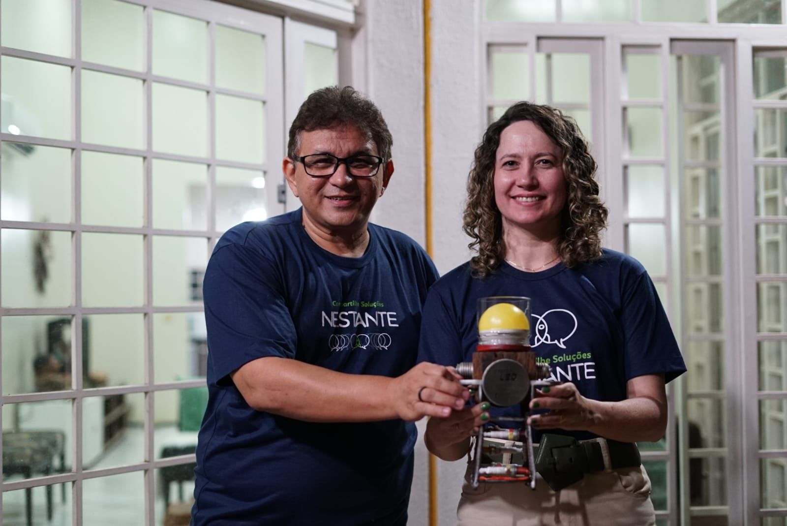 Jessé Barbosa e Graciele Barroso, coordenadores do Educar Nestante, com o troféu do Prêmio LED
